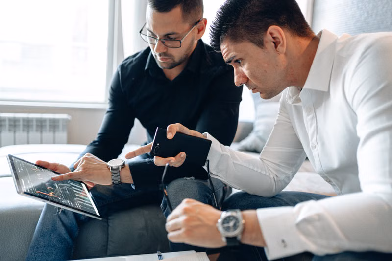 Two professionals analyzing financial data on a digital tablet